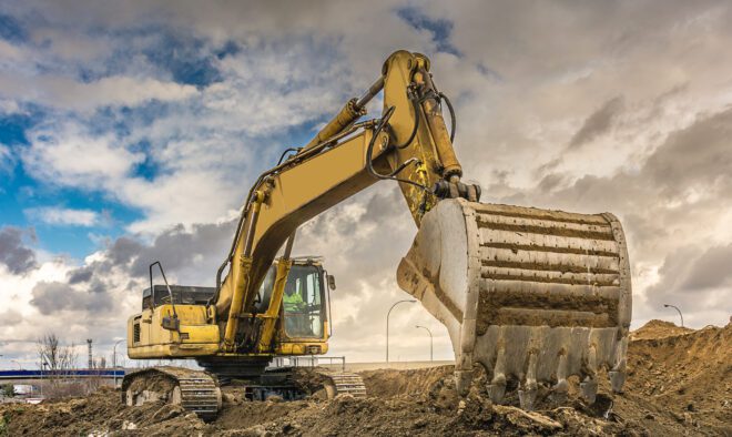 Excavator loading earth to perform works of settlement of a road